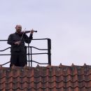 Artur Banaszkiewicz as a fiddler on the roof.  / RR Studio